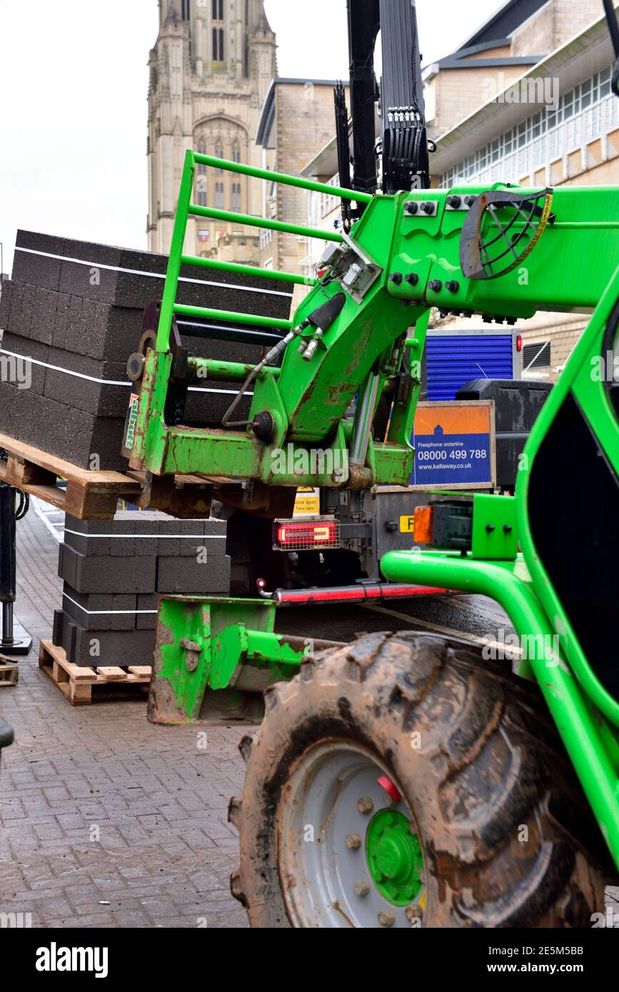 Carrello elevatore a forche con gru telescopica per sollevamento di blocchi di calcestruzzo per spostarsi sul cantiere Foto Stock