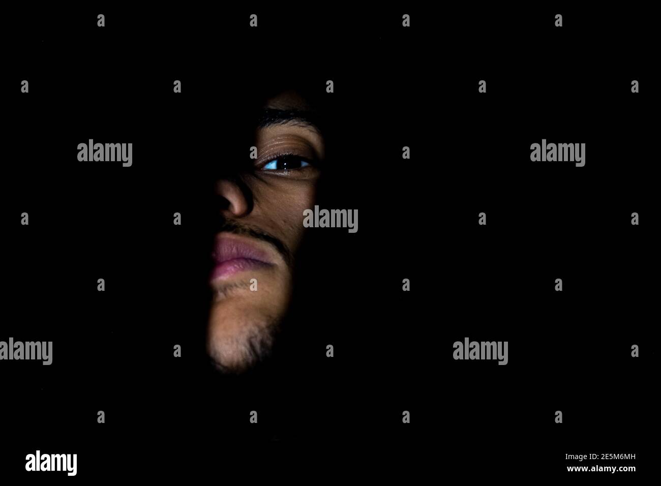 Ragazzo mediorientale con forme d'ombra sul viso Foto Stock