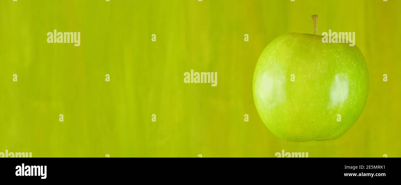 mela verde fresca su sfondo verde, alimentazione sana, cibo vegetariano mock up, spazio libero copia Foto Stock
