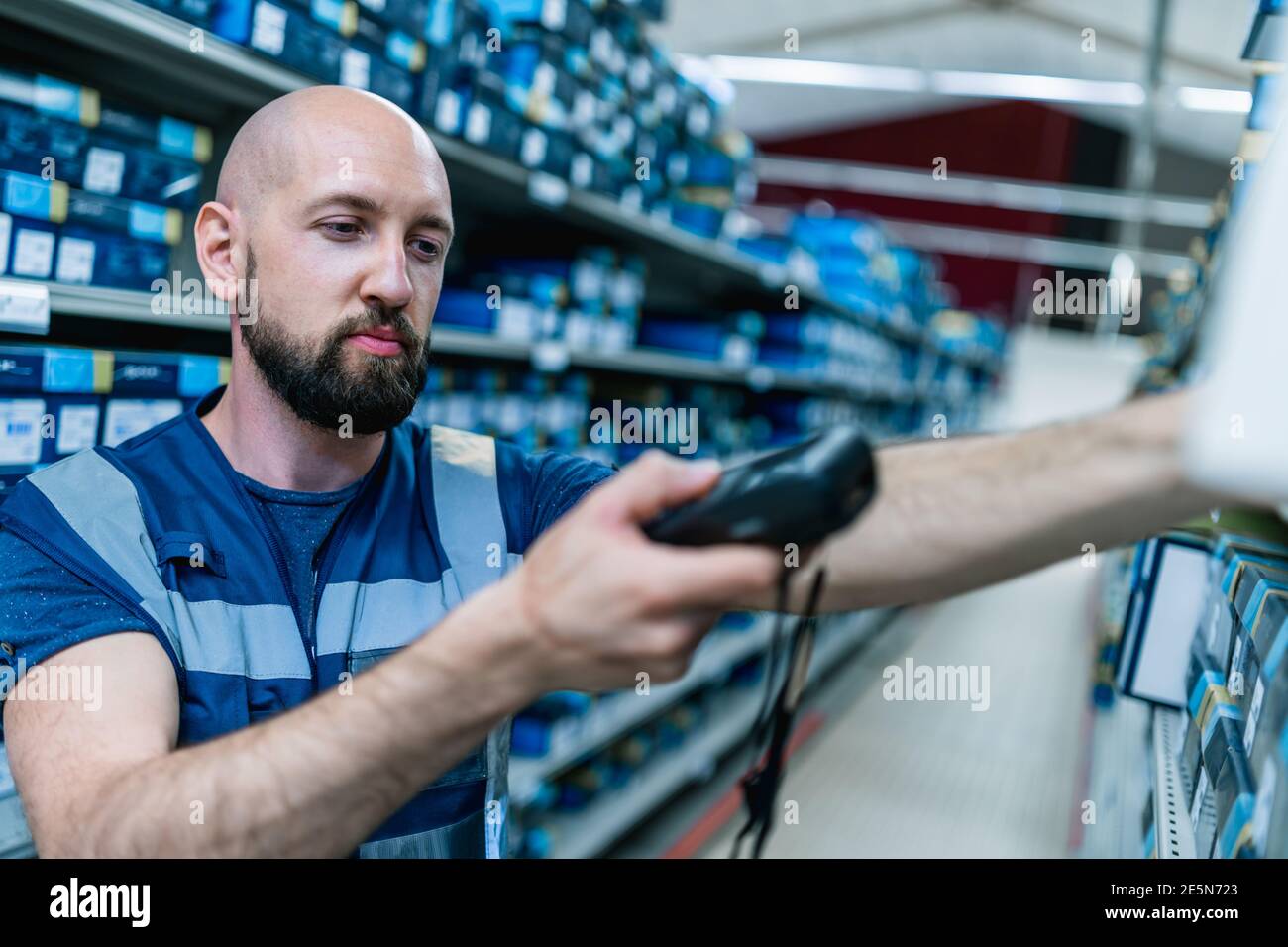 giovane uomo audace scansionare pacchi in un magazzino Foto Stock