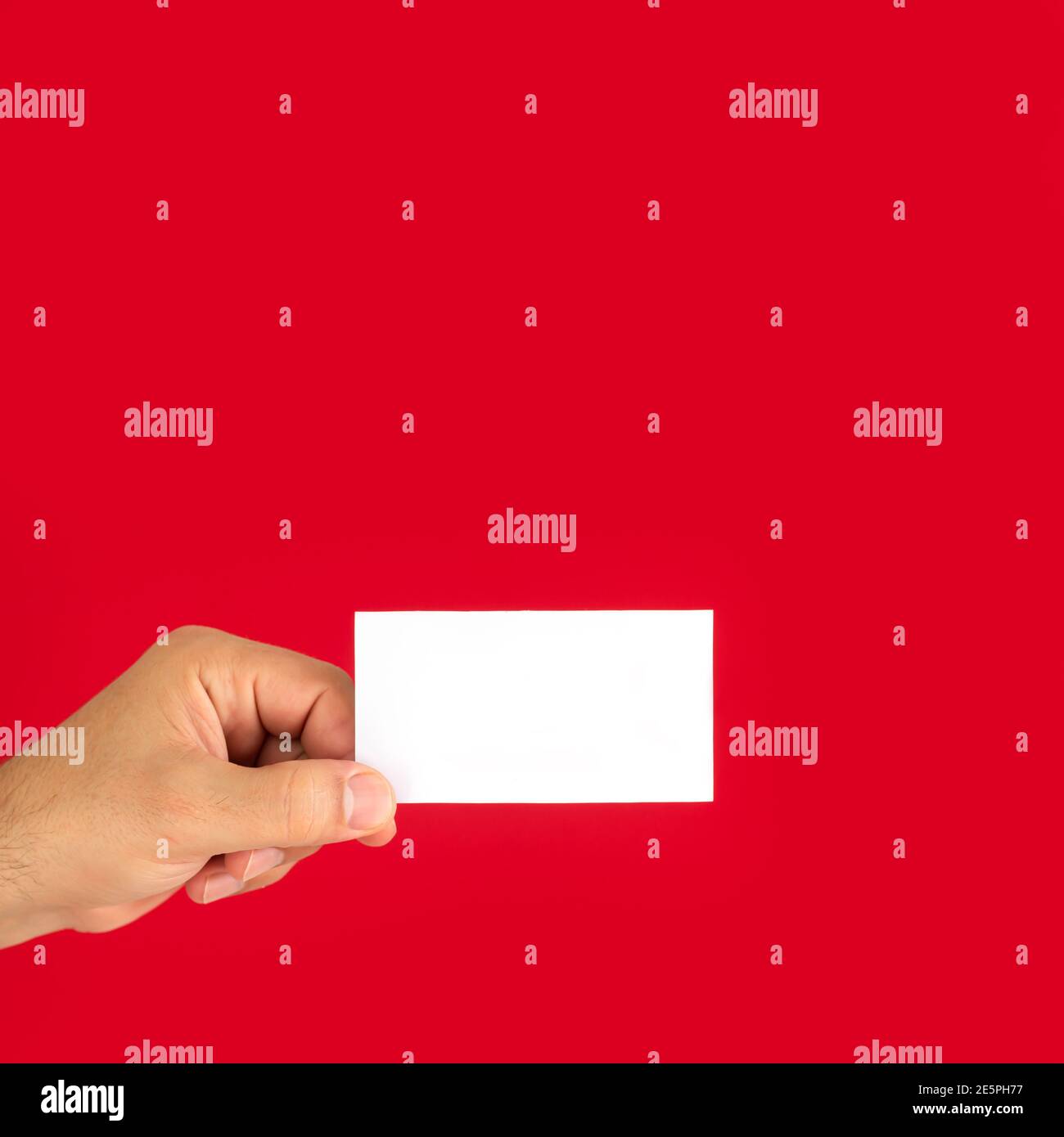 Uomo che mostra il biglietto da visita bianco vuoto isolato su sfondo rosso Foto Stock