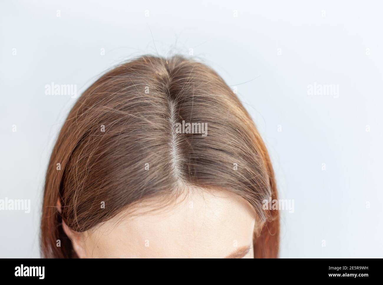 Testa di una donna con una separazione di capelli grigi. Foto Stock