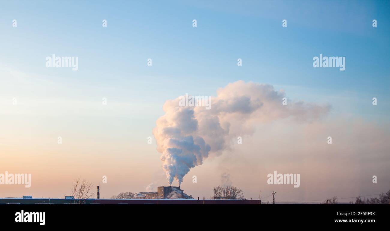 Fumo bianco spesso dal camino del locale caldaia. Zona industriale. Foto Stock