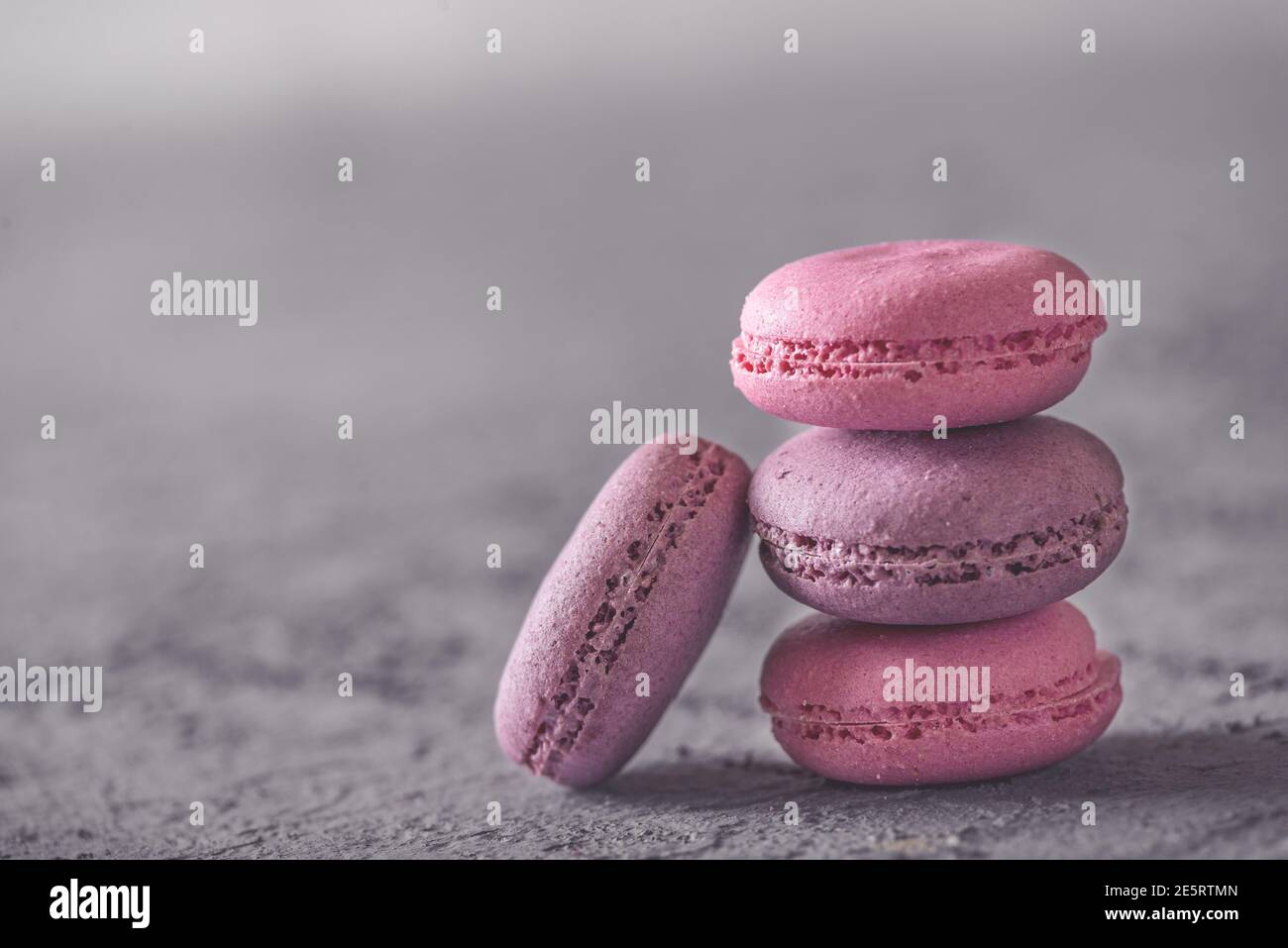 Bella colorata deliziosi dessert makarons, stack sulla pietra grigia sullo sfondo Foto Stock