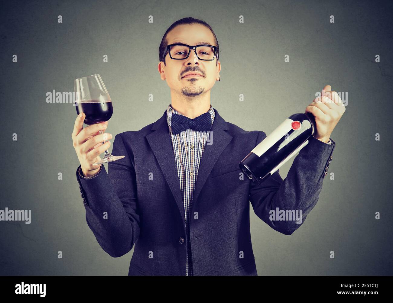 Ritratto di un esperto di vino che tiene un bicchiere di rosso vino e una bottiglia Foto Stock