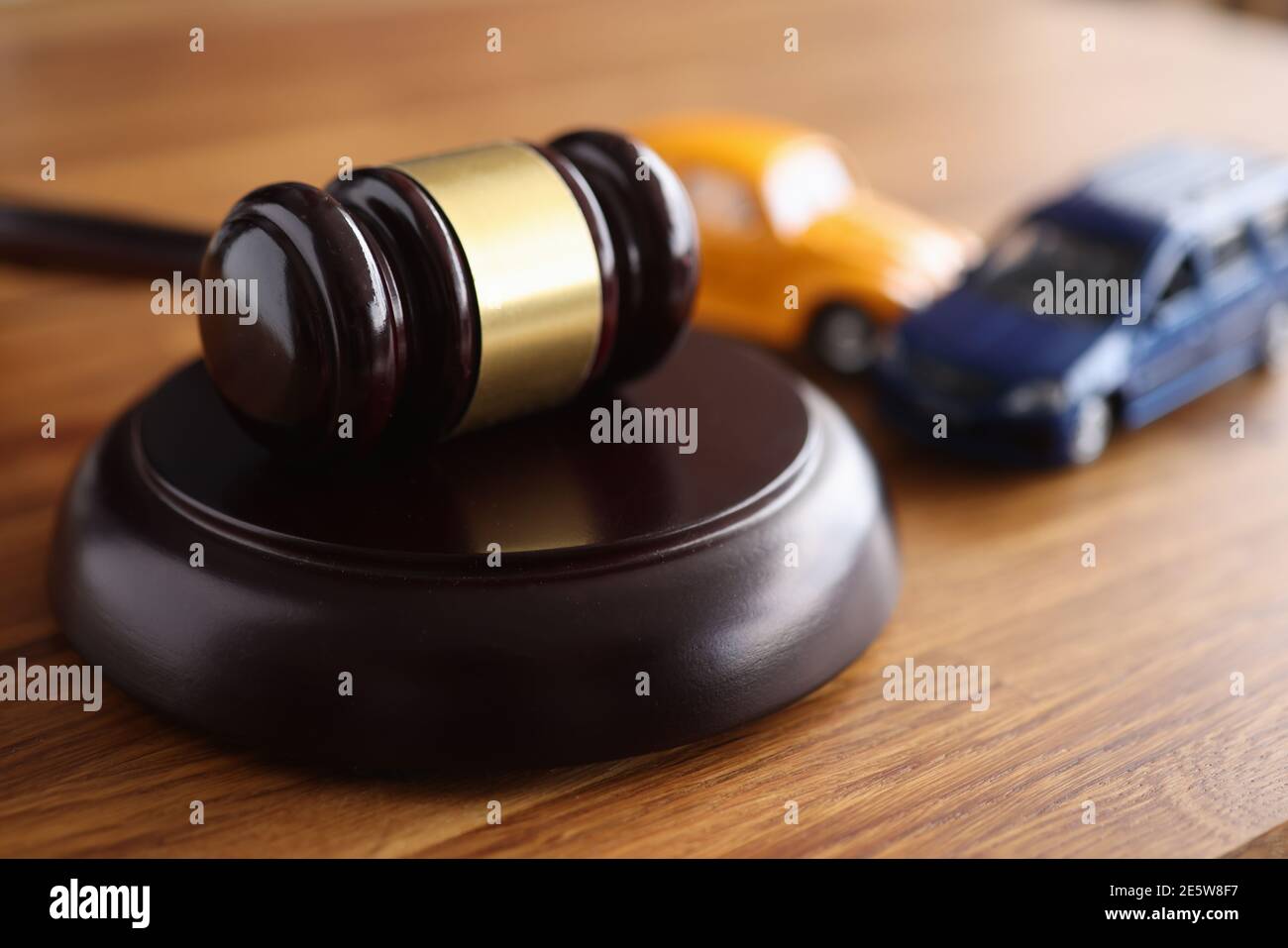 Giudica gavel di legno che giace sul tavolo vicino a macchine giocattolo closeup Foto Stock
