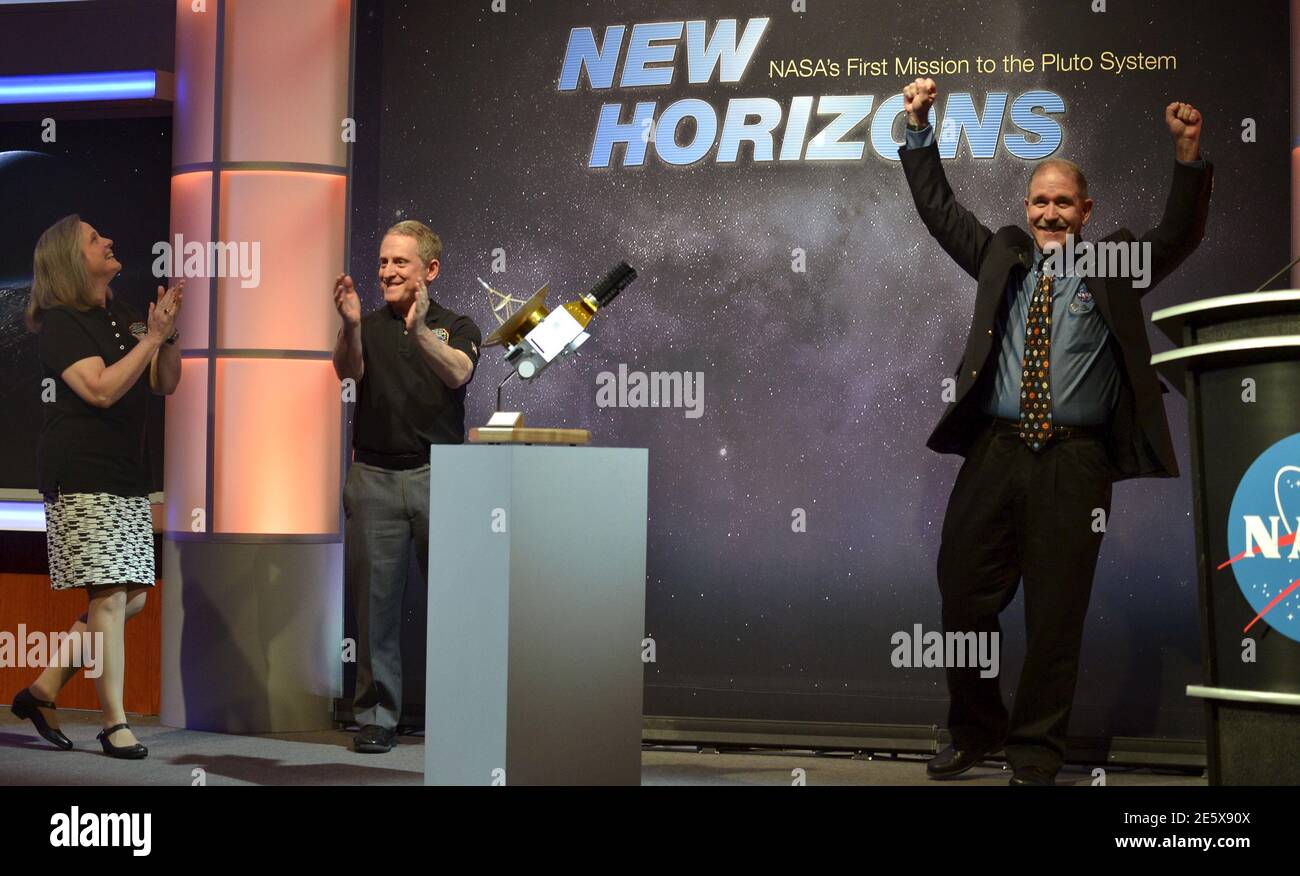 Alan Stern (C), responsabile investigatore della missione dei nuovi orizzonti della NASA, si unisce alla simpatizzazione con l'amministratore associato John Grunsfeld (R) e con il Mission Operations Manager Alice Bowman, mentre il veicolo spaziale New Horizons si avvicina a un flyby di Plutone, presso il Johns Hopkins Applied Physics Laboratory della NASA a Laurel, Maryland, 14 luglio 2015. Più di nove anni dopo il suo lancio, una navicella spaziale statunitense ha navigato oltre Plutone martedì, per un viaggio di 4.88 miliardi di miglia verso le più lontane distanze del sistema solare, ha dichiarato la NASA. Il mestiere volò dal lontano pianeta 'nano' alle 7:49 dopo aver raggiunto una regione Foto Stock