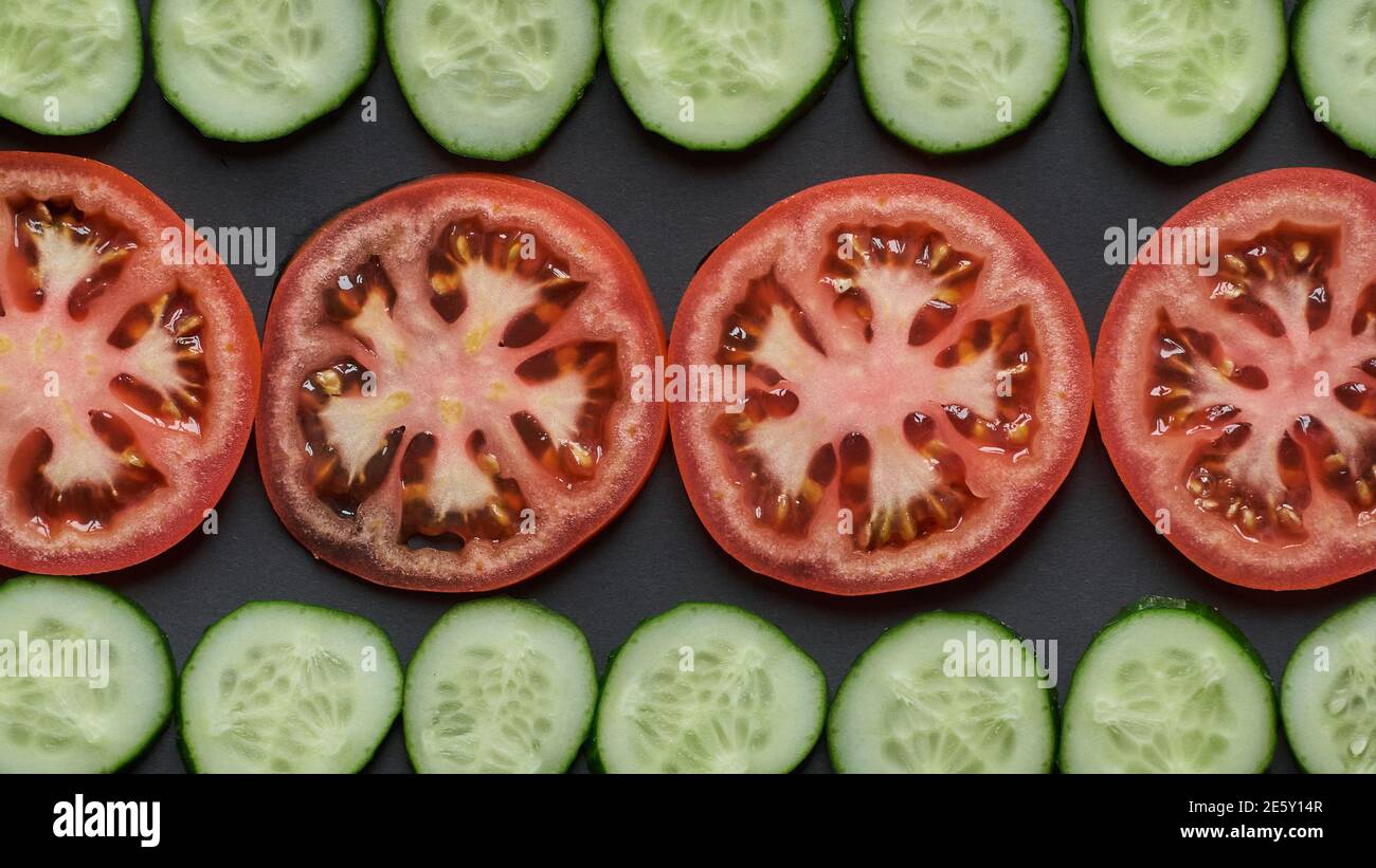 Pomodoro e cetrioli. Fette di verdure su sfondo nero. Foto di alta qualità Foto Stock