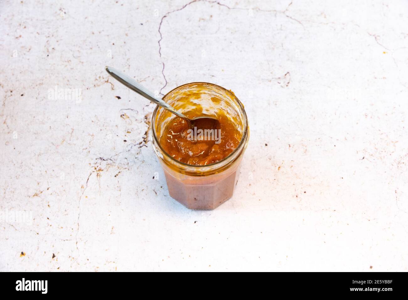 Un vasetto di marmellate di albicocche fatte in casa su sfondo marmoreo. Foto Stock