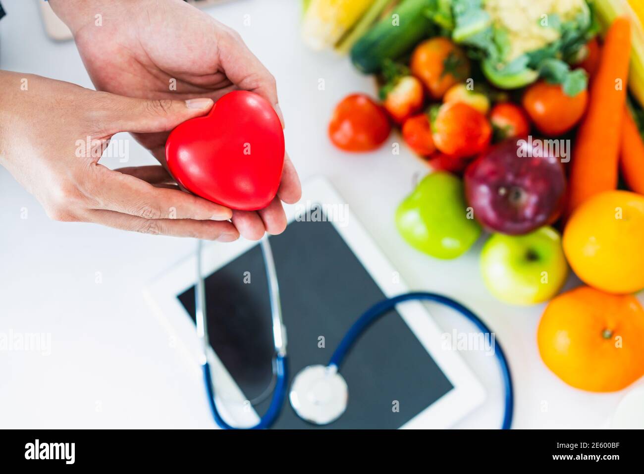 Dieta alimentare di frutta e verdura per il controllo del colesterolo con mani nutrizioniste che mostrano consapevolezza e prevenzione delle malattie cardiache. Mangiare sano Foto Stock