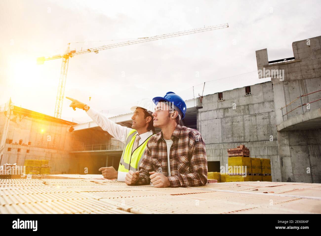 Lavoratori edili a discutere il lavoro al sito di costruzione Foto Stock