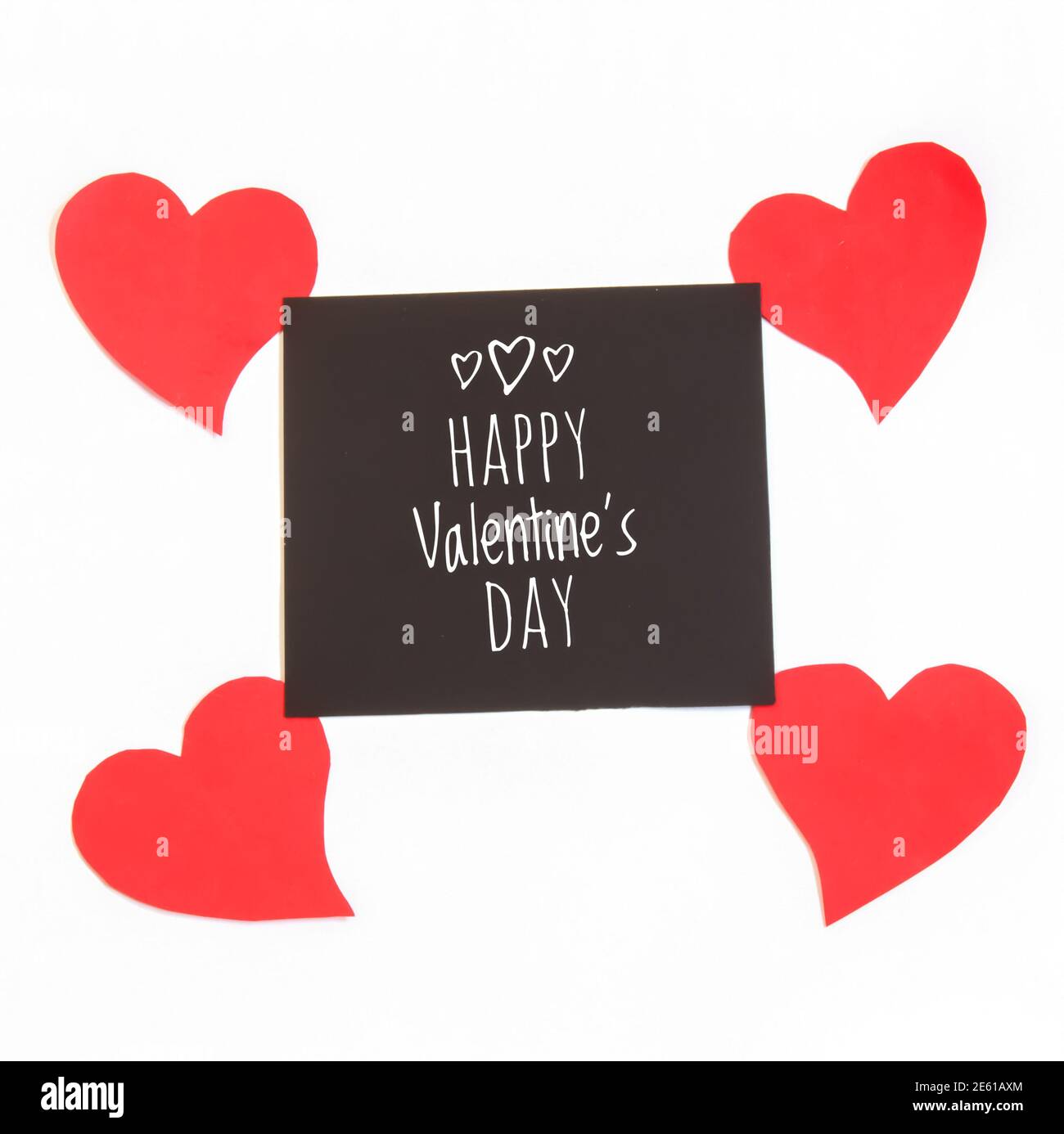 Cuori rossi e cartellino nero inscritto 'buon San Valentino' isolato su sfondo bianco. Febbraio 14 concetto di San Valentino. Foto Stock