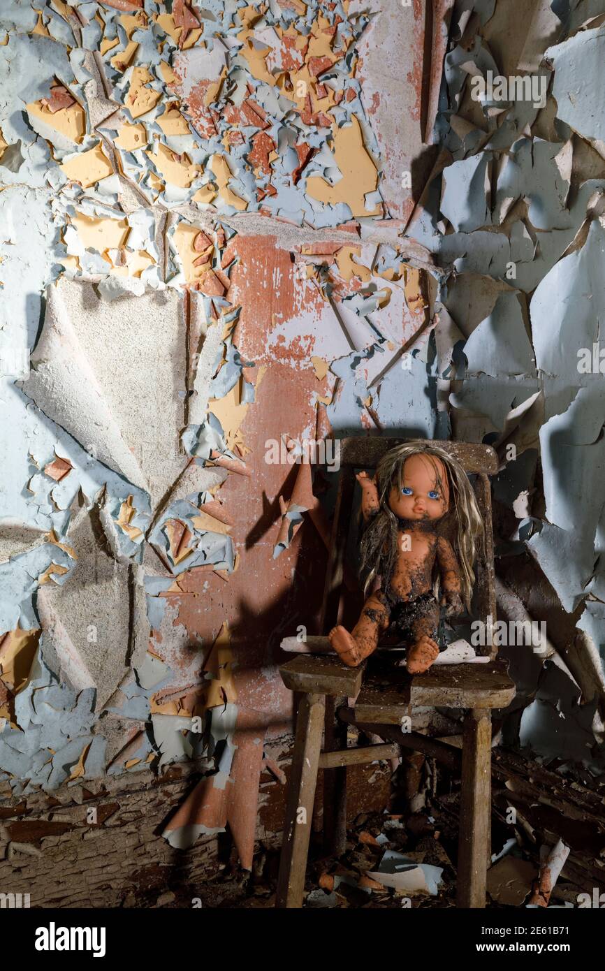 Una bambola per bambini che si allontana all'interno di una casa abbandonata con vernice da peeling. Ontario, Canada. Foto Stock