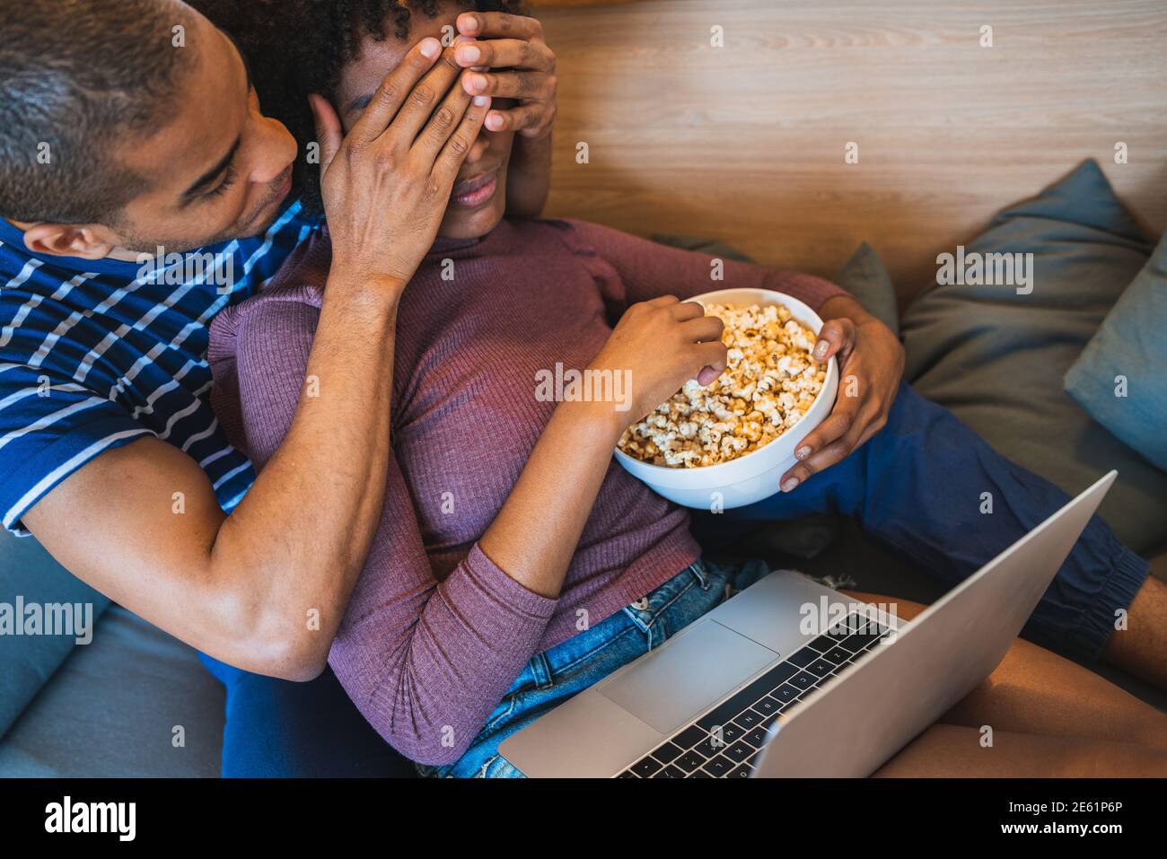 Coppia latina che guarda un film con un computer portatile a casa. Foto Stock