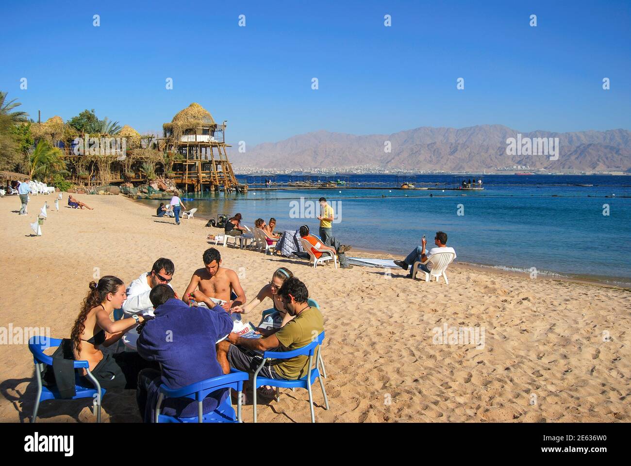 Gruppo a tavola sulla spiaggia, Dolphin Reef, Eilat, Distretto Sud, Israele Foto Stock