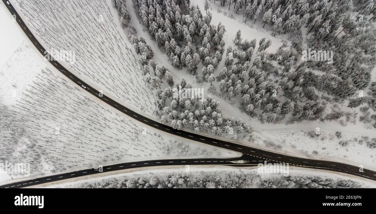 Vista aerea del paesaggio invernale innevato di Winterberg con strade tortuose e sentieri con una forcella a V a Sauerland nel Nord Reno-Westfalia, Ger Foto Stock