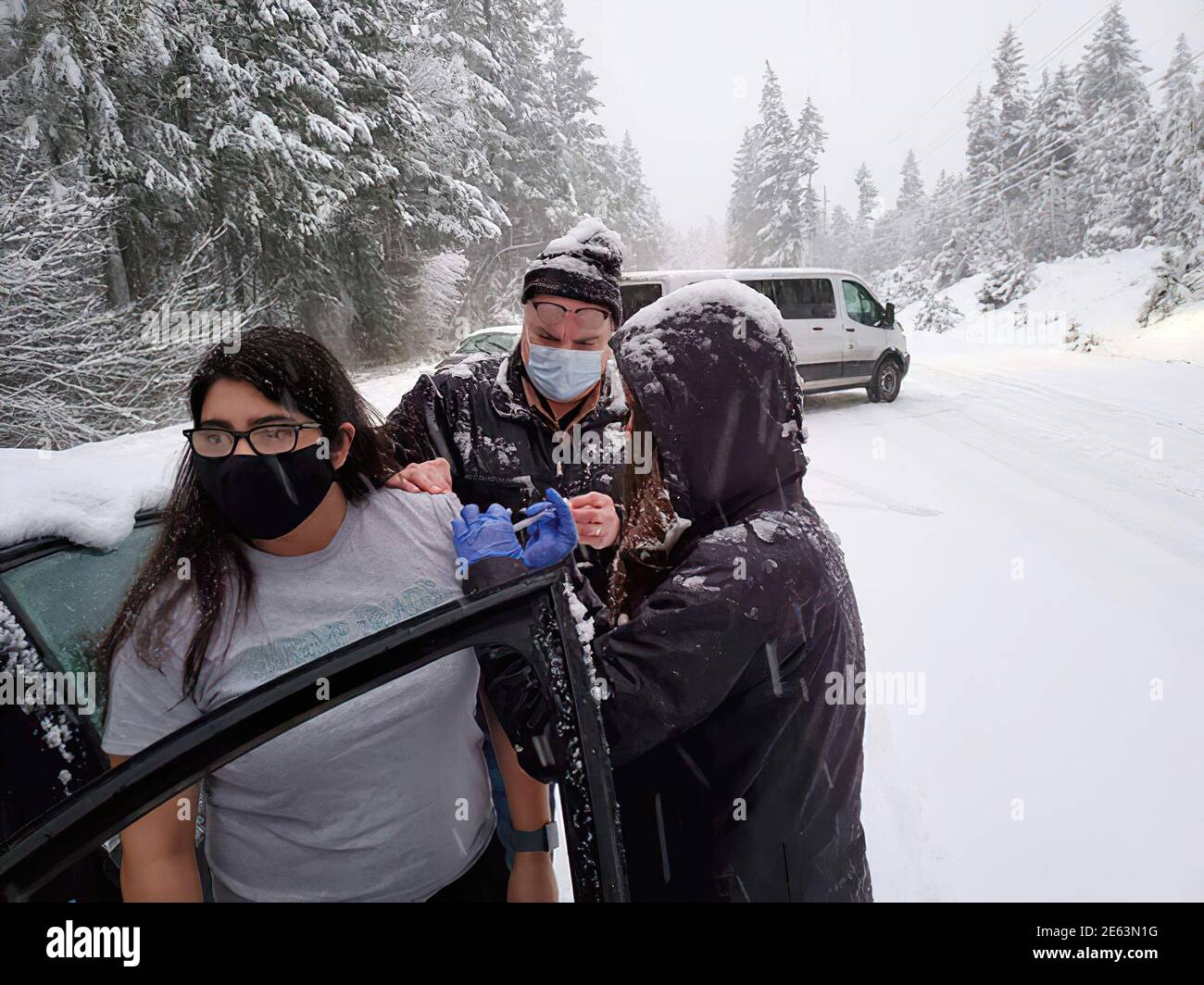 Gli operatori sanitari dell'Oregon si spingano sempre più in questo modo. Anche la neve non ha fatto fermare questi operatori sanitari della contea di Josephine dal garantire che non sono stati sprecati vaccini, vaccinando i conducenti in attesa che la strada fosse sgombrata in una clinica improvvisata sull'autostrada 199. Foto Stock