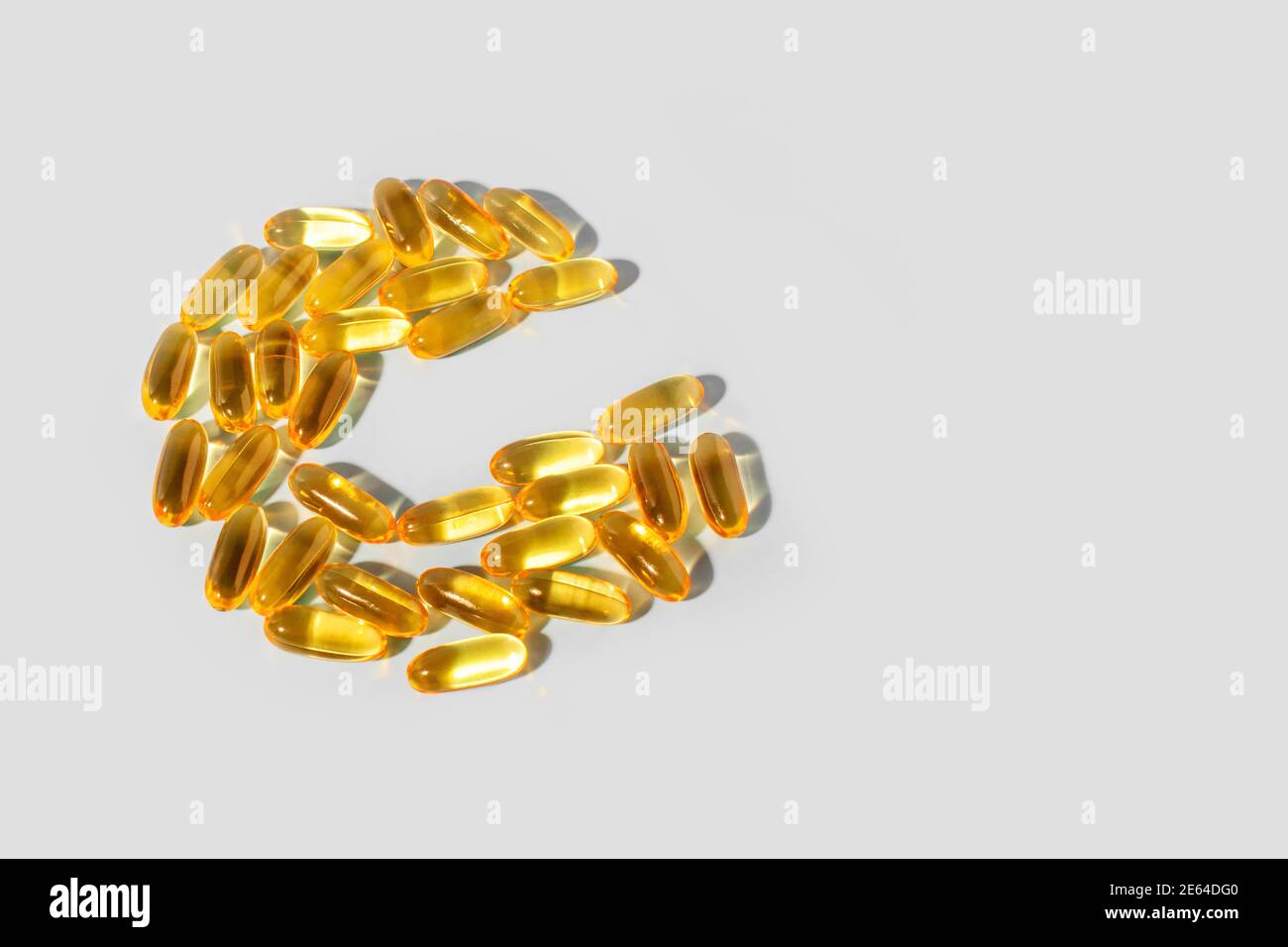 Capsule di gelatina gialle su fondo grigio a forma di C. integratore  alimentare, vitamina C Foto stock - Alamy