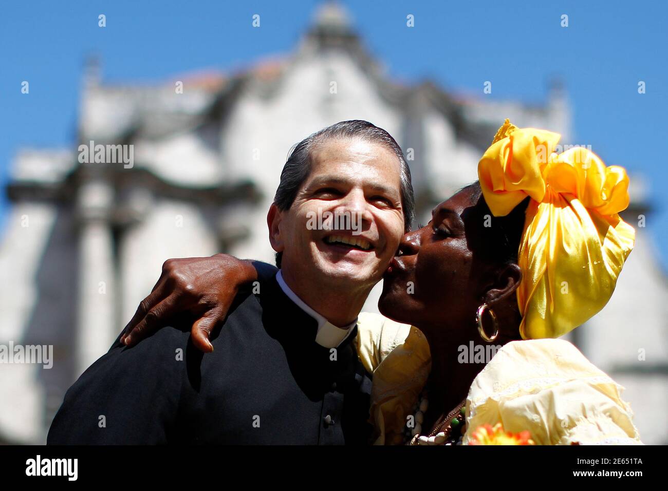 Il sacerdote cattolico venezuelano Luis Eduardo Rodriguez riceve un bacio  dal lavoratore turistico-accogliente Rosa di fronte ad una cattedrale a la  Habana 24 marzo 2012. Il Santo Padre Benedetto ha detto venerdì