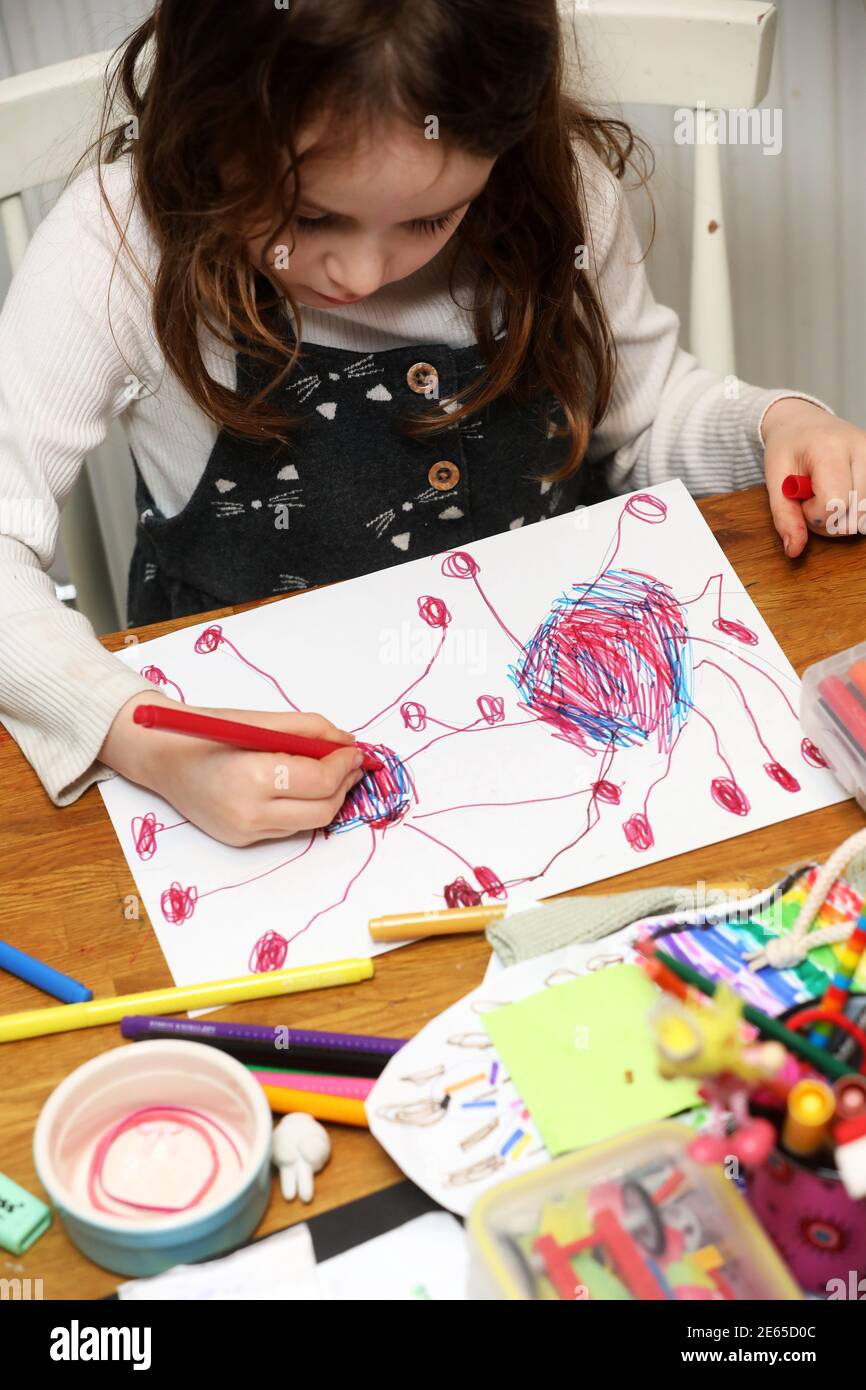 Una giovane ragazza ha ritratto disegnando un bug di Coronavirus durante la scuola di casa e Lockdown 3 a Sussex, Regno Unito. Foto Stock