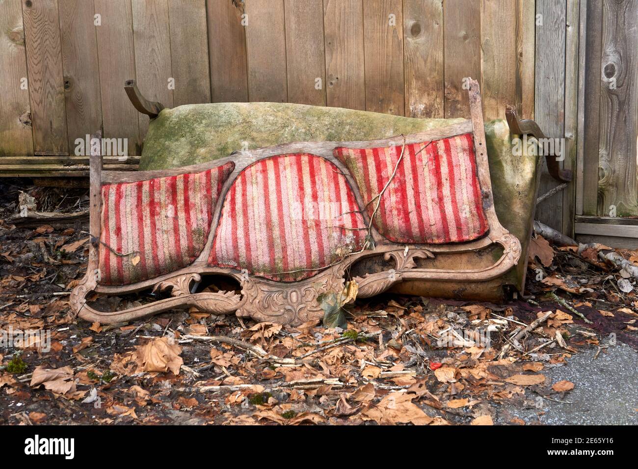Scartato e rotto vecchio divano di legno sdraiato in una schiena vicolo Foto Stock