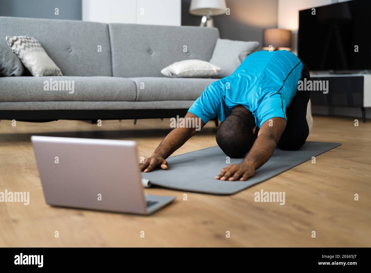 African American fare in linea che allunga la classe di workout di idoneità a casa Foto Stock