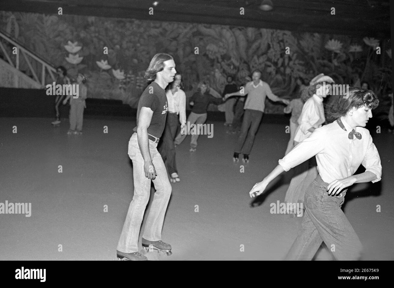 Keith Carradine skates Past Jon Voigt al Flippers Roller disco evento a sostegno di era, Los Angeles, ottobre. 29, 1978 Foto Stock