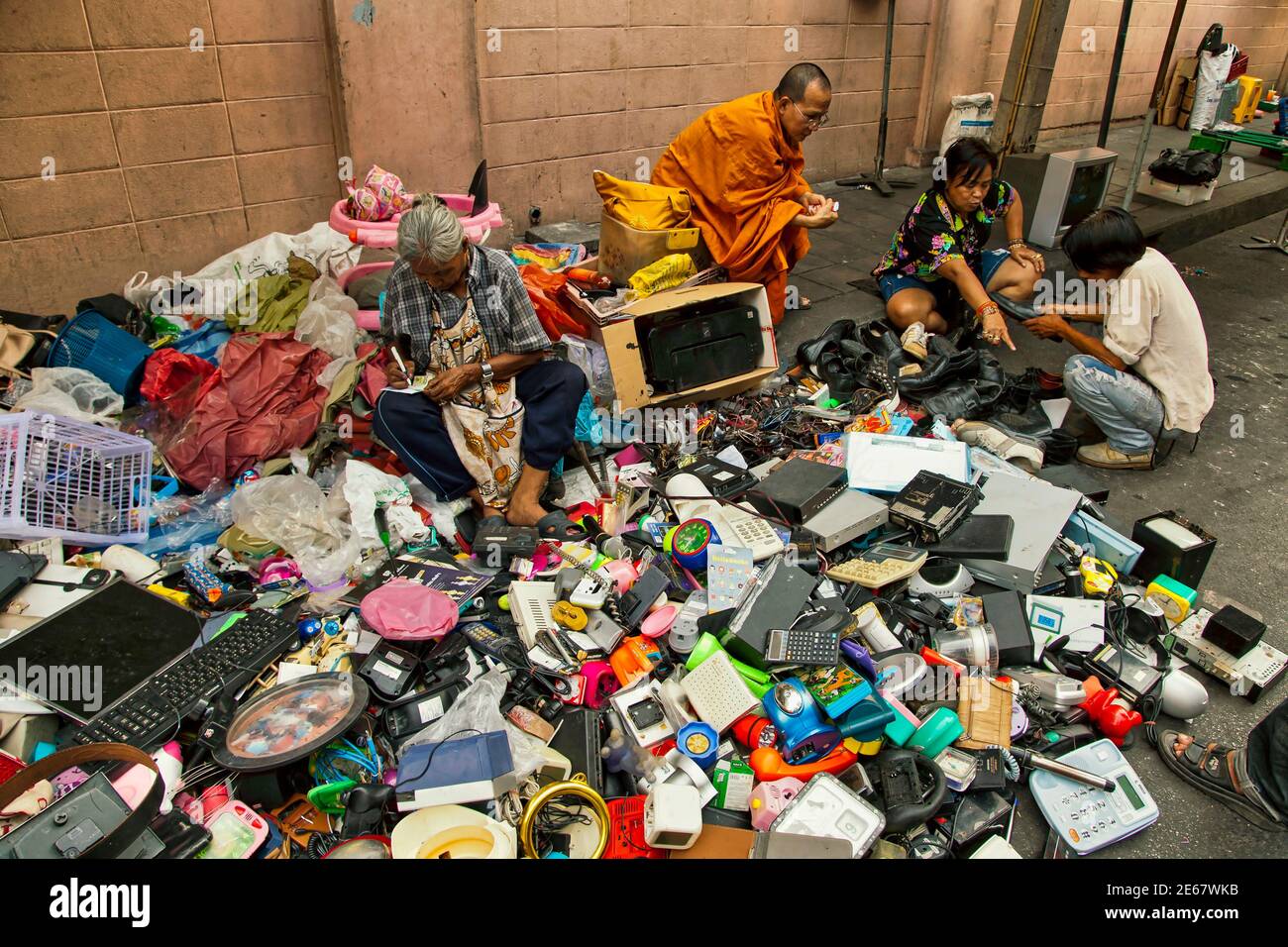 Un monaco buddista percorre il "gizzmo" elettronico in una strada laterale di China Town, Bangkok, Thailandia Foto Stock