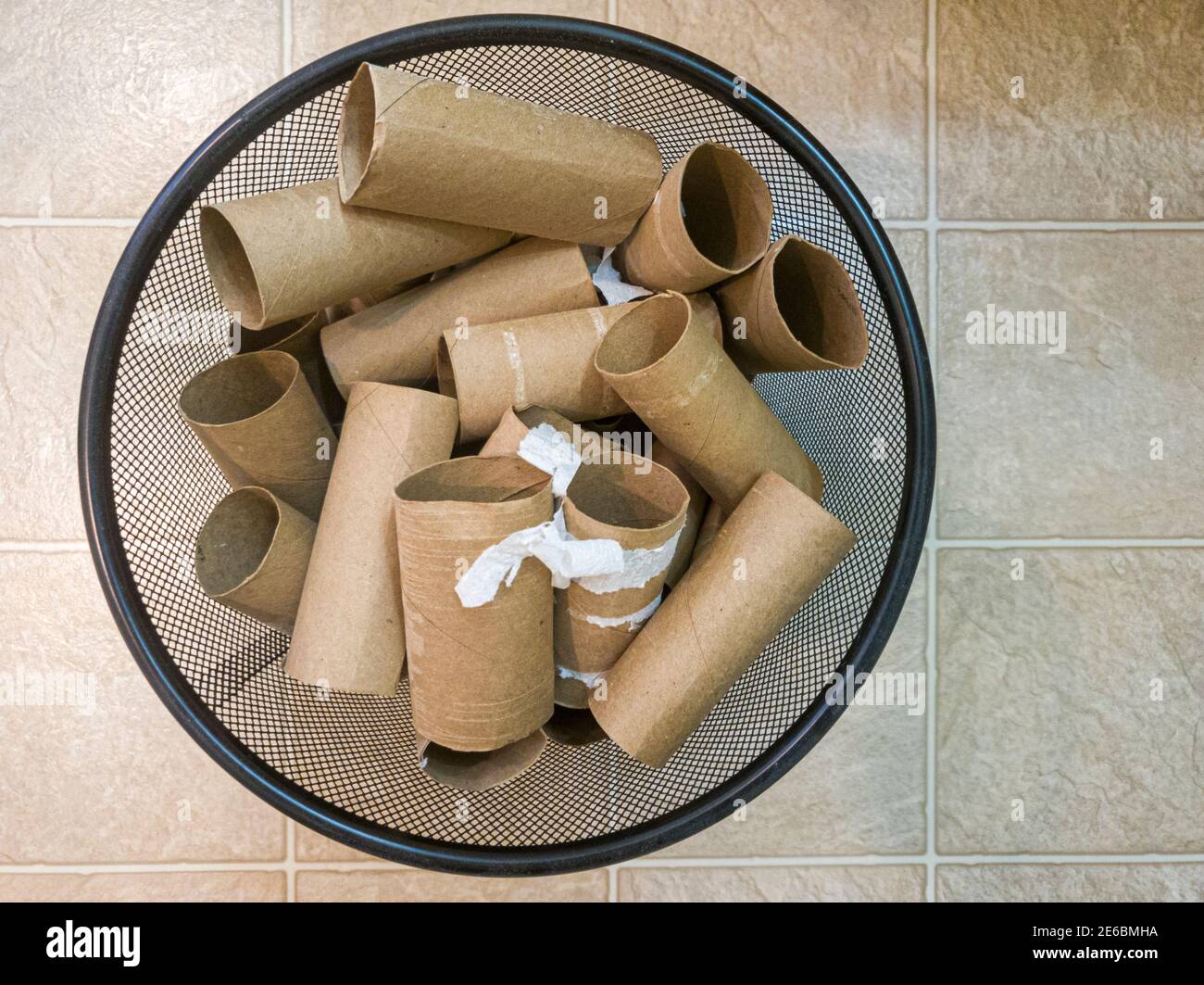 Immagine dall'alto di un raccoglitore di rifiuti in metallo pieno di rotoli di carta igienica vuoti con alcuni residui di carta attaccati su di essi. Un'immagine concettuale per l'acquisto, hoa Foto Stock