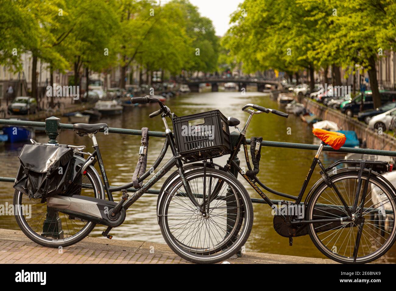 Amsterdam, Olanda 05-15-2010: Le classiche bici di vecchio stile sono concatenate alle ringhiere metalliche di uno dei ponti sopra la famosa rete di canali di Amsterdam Foto Stock