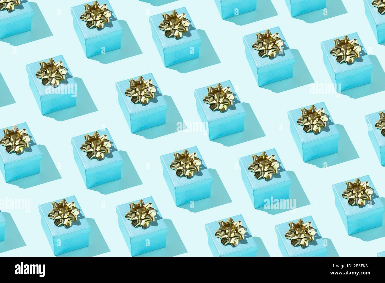 Confezione regalo con arco dorato sul blu pastello sfondo festivo sfondo minimal design trendy Foto Stock