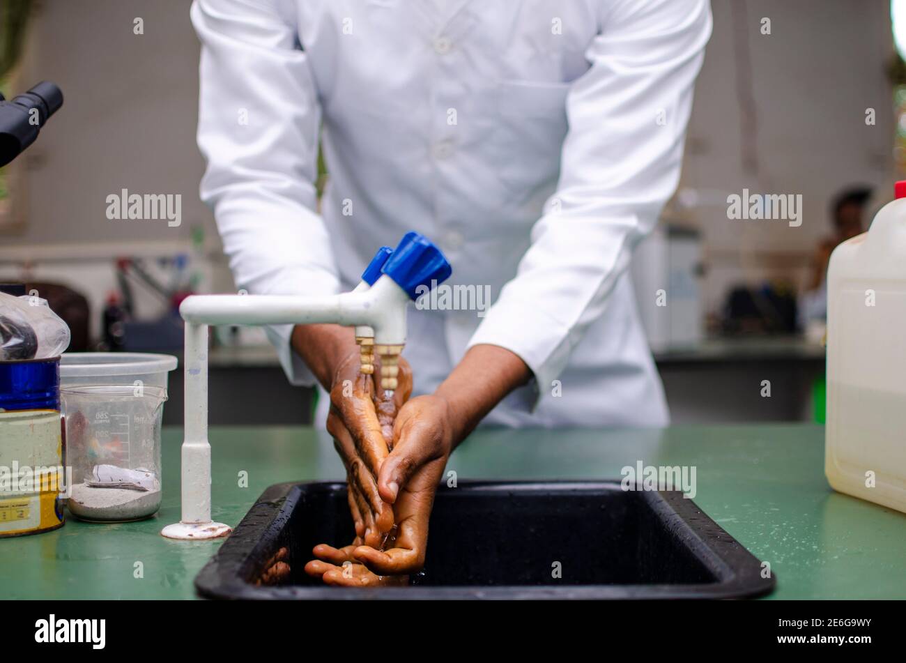 Giovane medico nero lavando le mani in laboratorio Foto Stock