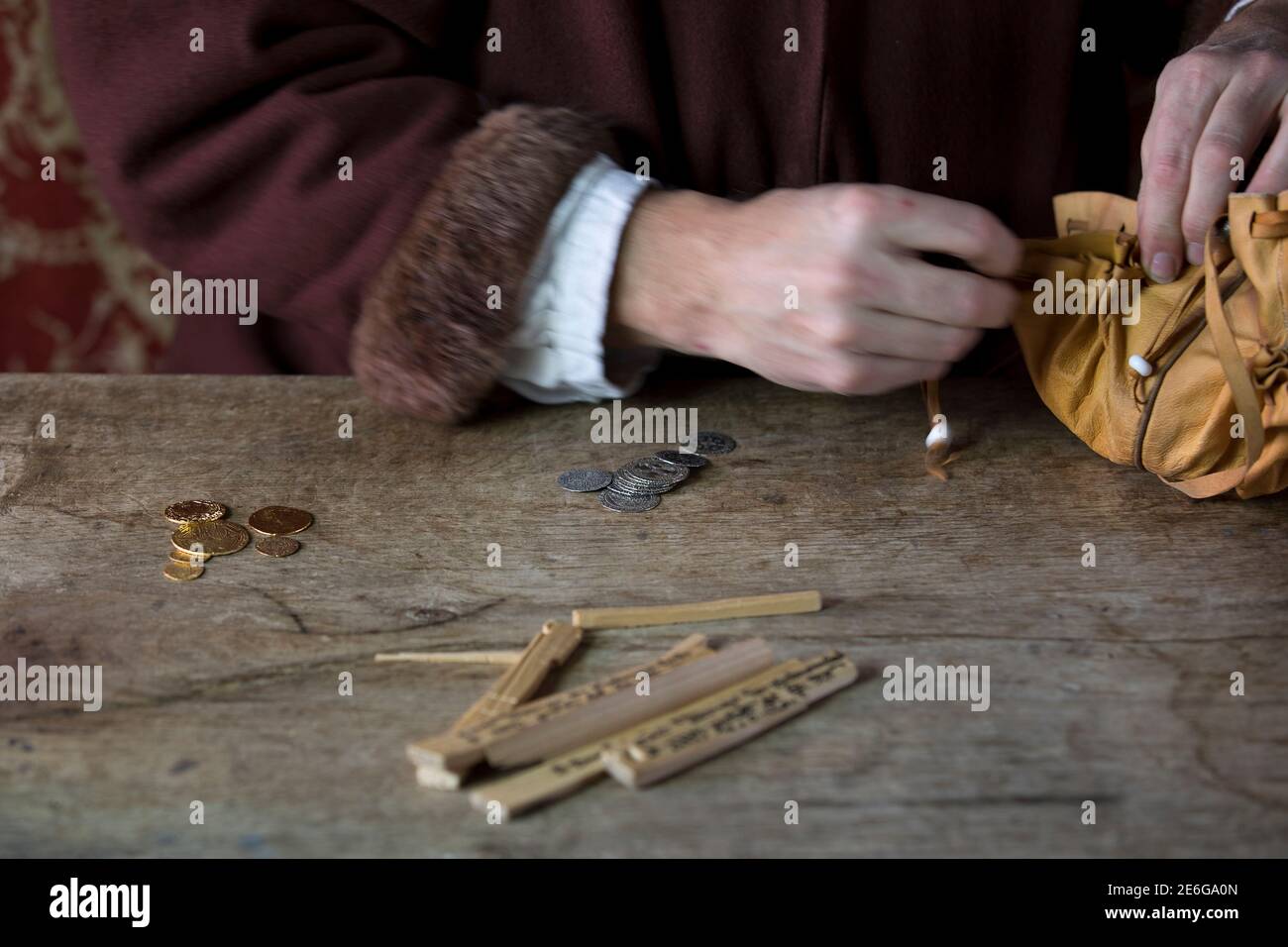 Mercante medievale contando denaro utilizzando i bastoni tally Foto Stock