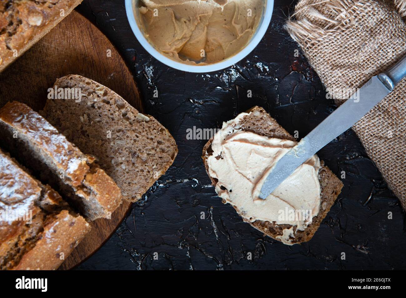 Pezzo intero di pane di grano spalmato con pate di funghi. Panino vegetariano. Piatto vegetariano. Foto Stock