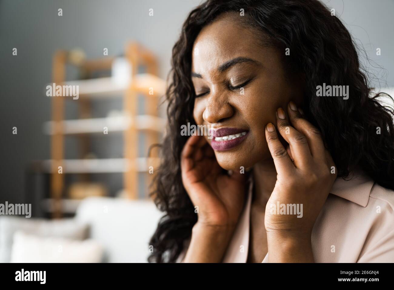 Donna afroamericana con dente dolente e decadimento. Mal di denti Foto Stock
