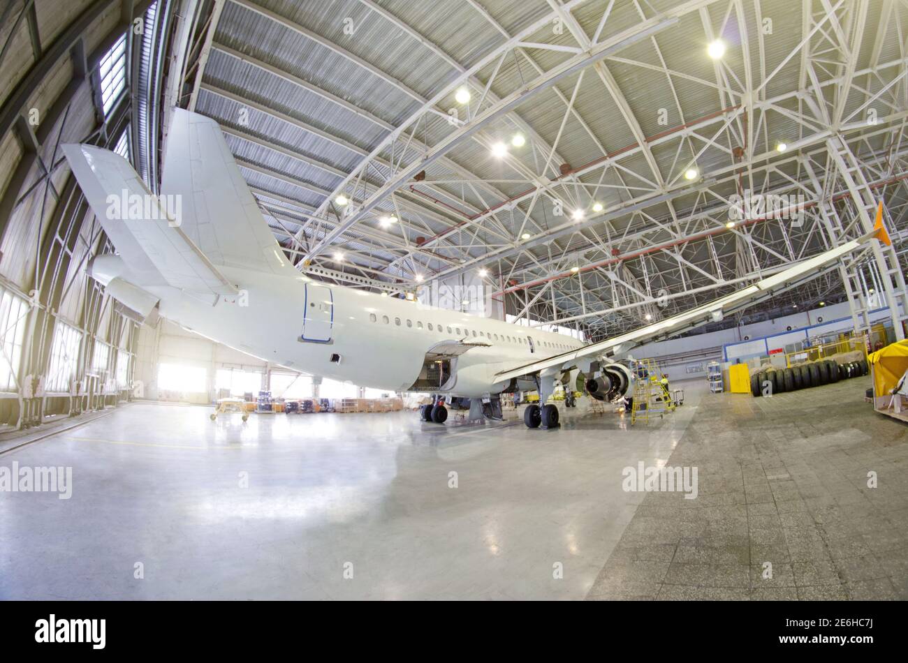 Aereo passeggeri su manutenzione motore, fusoliera e su unità di potenza ausiliaria. Controllare la riparazione in hangar aeroporto. Coda vista velivolo, con lugga aperto Foto Stock