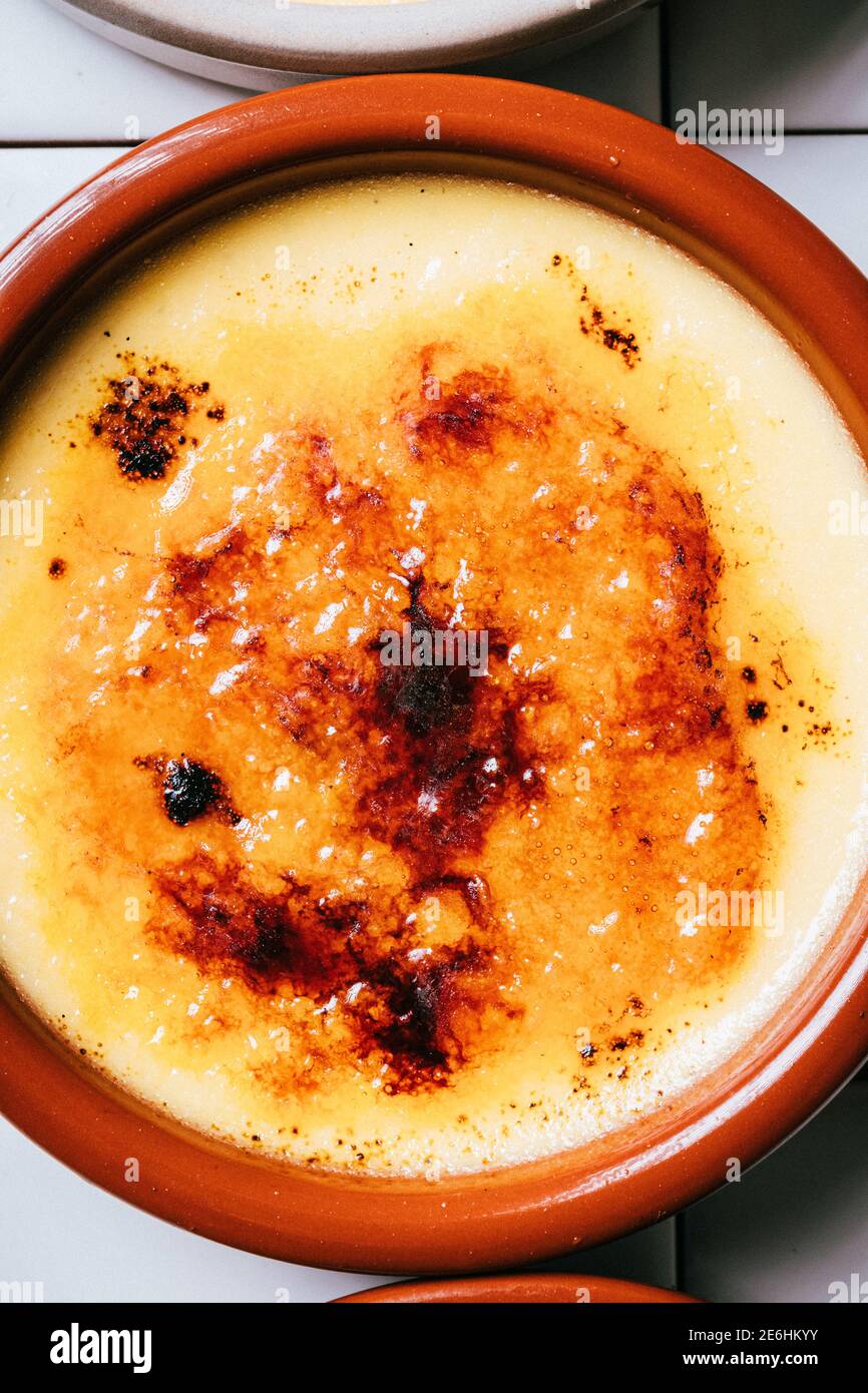 Primo piano di più crametini di creme brulee su uno sfondo bianco tegola. Foto Stock