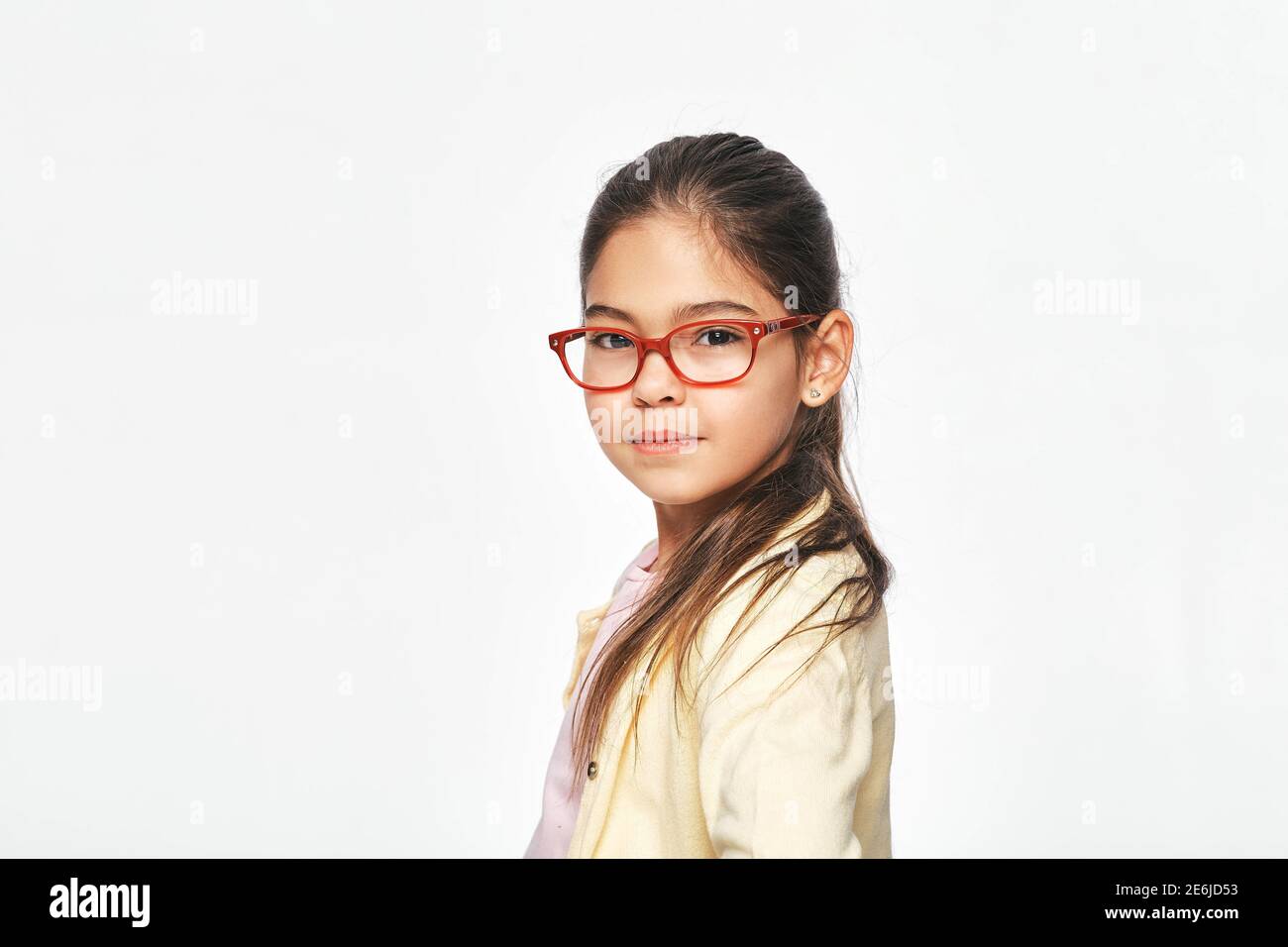 Bella bambina latino-americana in occhiali eleganti rossi sfondo grigio chiaro Foto Stock