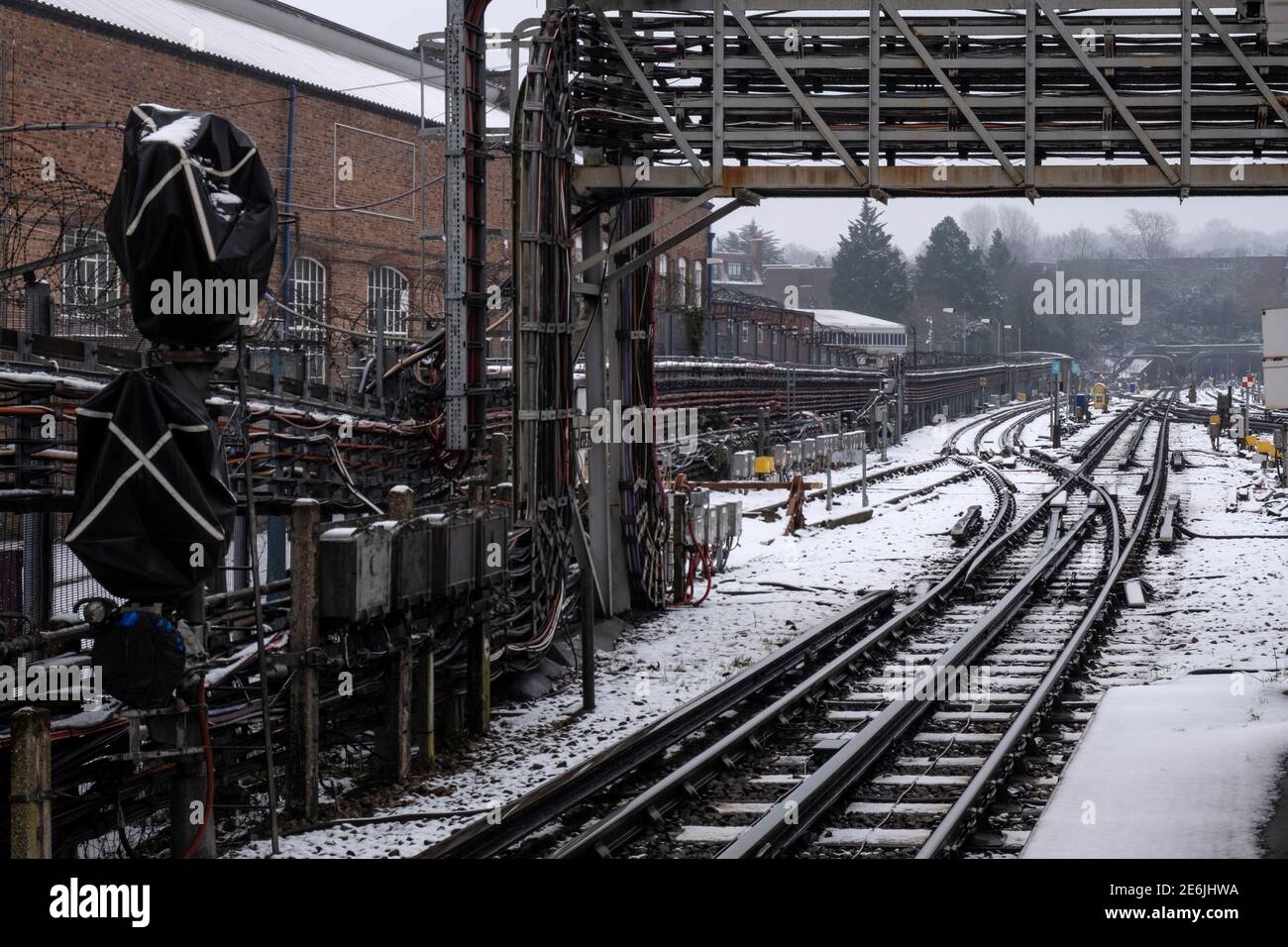 Binari ferroviari coperti di neve fuori da una stazione metropolitana di Londra, segnali, non persone Foto Stock