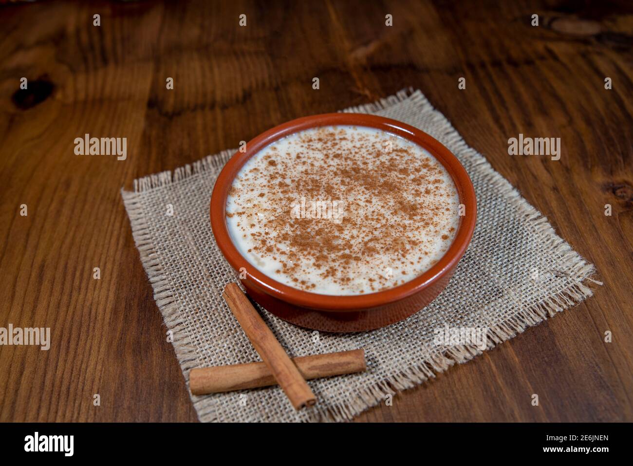 Porridge di riso alla cannella in una ciotola su uno sfondo di legno chiaro. Cibo visto dall'alto Foto Stock