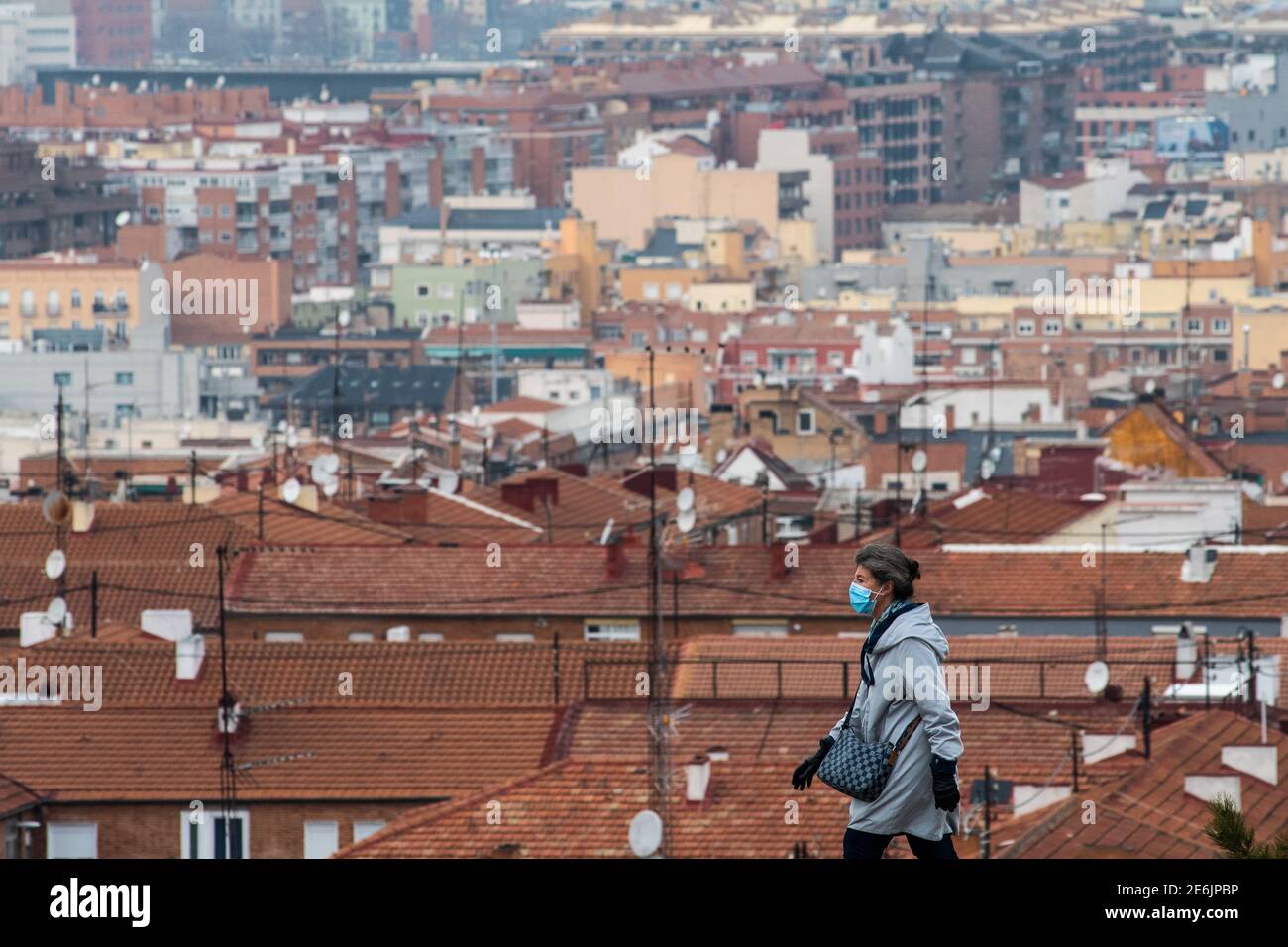 Madrid, Spagna. 29 gennaio 2021. Una donna che indossa una maschera per fermare la diffusione del coronavirus, fa una passeggiata con la vista dei tetti di Madrid. Il Vice Ministro della Sanità pubblica e del piano Covid-19, Antonio Zapatero, ha sottolineato oggi che 'a Madrid c'è una situazione di alta trasmissione comunitaria, anche se tutto indica un rallentamento e un cambiamento di tendenza, Che diminuirà i casi con coronavirus nella regione tuttavia la pressione sanitaria continua ad essere molto alta, con 4,956 pazienti, 700 dei quali sono in UTI 'Credit: Marcos del Mazo/Alamy Live News Foto Stock