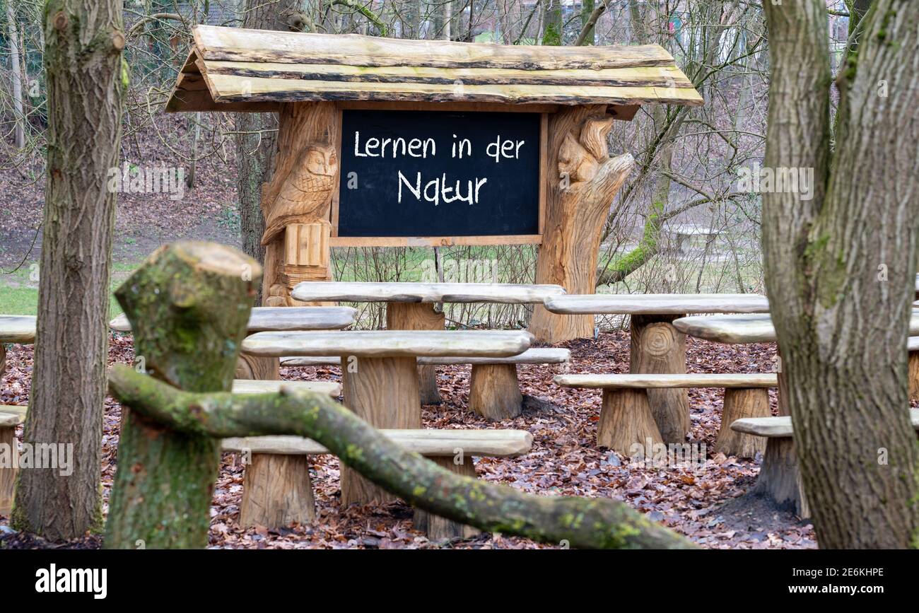 Un'aula nella foresta. Il testo tedesco 'lernen in der Naur' (imparare nella natura) è scritto su una lavagna. Foto Stock