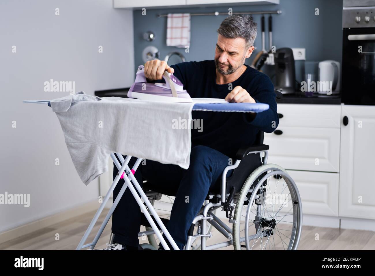 Uomo disabili in abiti da stiro per sedie a rotelle Foto Stock