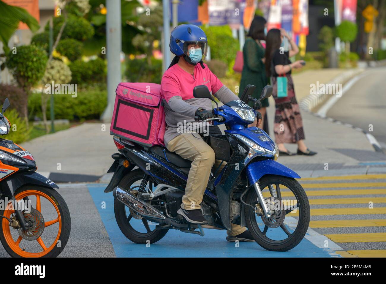 (210129) -- KUALA LUMPUR, 29 gennaio 2021 (Xinhua) -- UN pilota di consegna di cibo che indossa una maschera facciale attende i semafori a Kuala Lumpur, Malesia, 29 gennaio 2021. La Malesia ha registrato 5,725 casi confermati di COVID-19 nel suo picco quotidiano più alto dopo lo scoppio del coronavirus nel paese asiatico, portando il suo totale a 203,933, il Ministero della Salute ha detto Venerdì. (Foto di Chong Voon Chung/Xinhua) Foto Stock