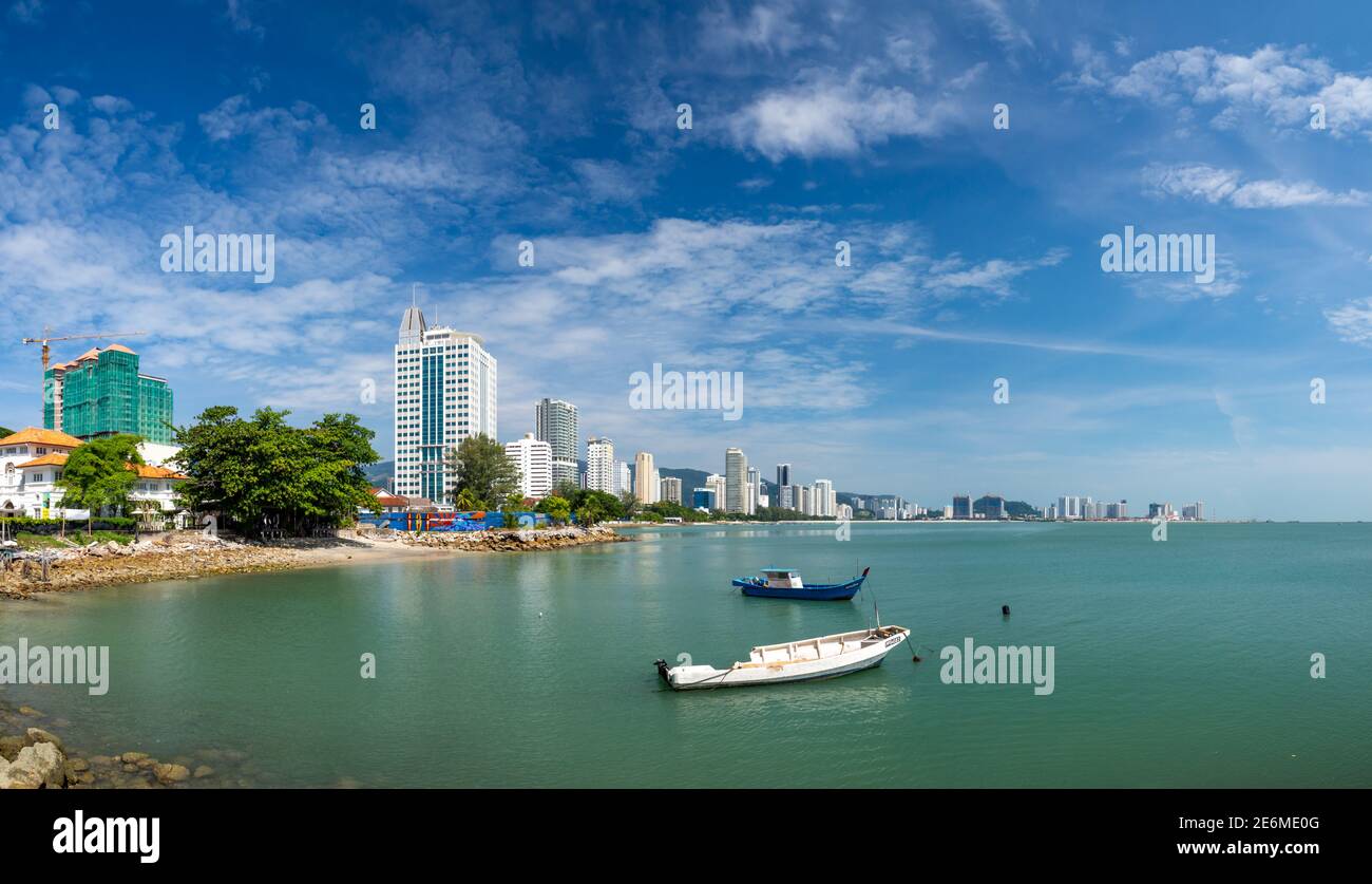 George Town, Penang, Malesia: Vista panoramica della città e della spiaggia con lungomare, alberghi e barche da pesca Foto Stock