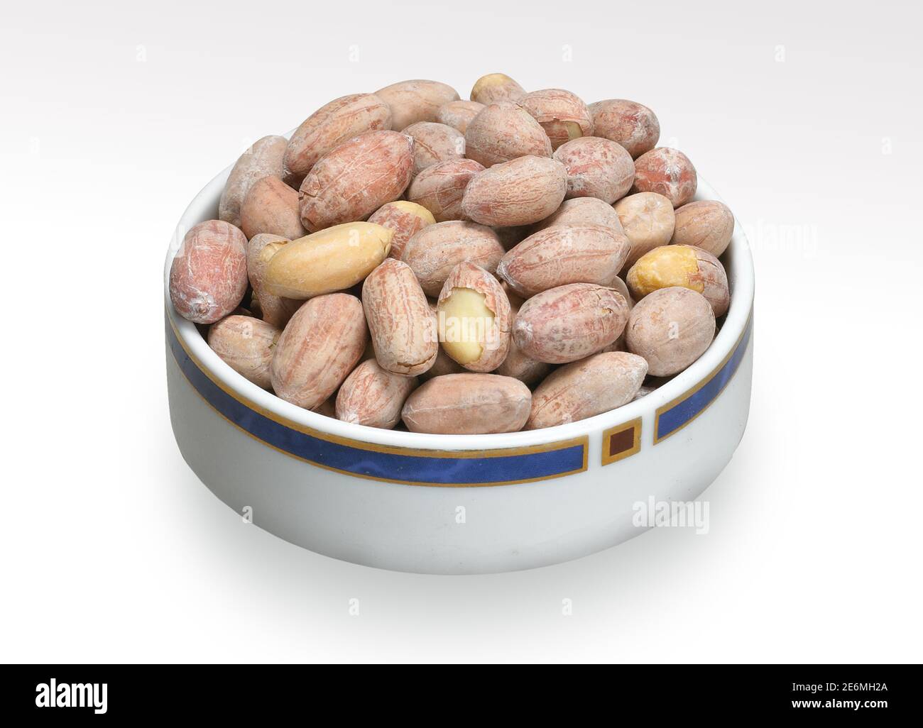 Arachidi arrostite, arachidi salate, grani, noci, conchiglia o canto, su fondo bianco della ciotola Foto Stock