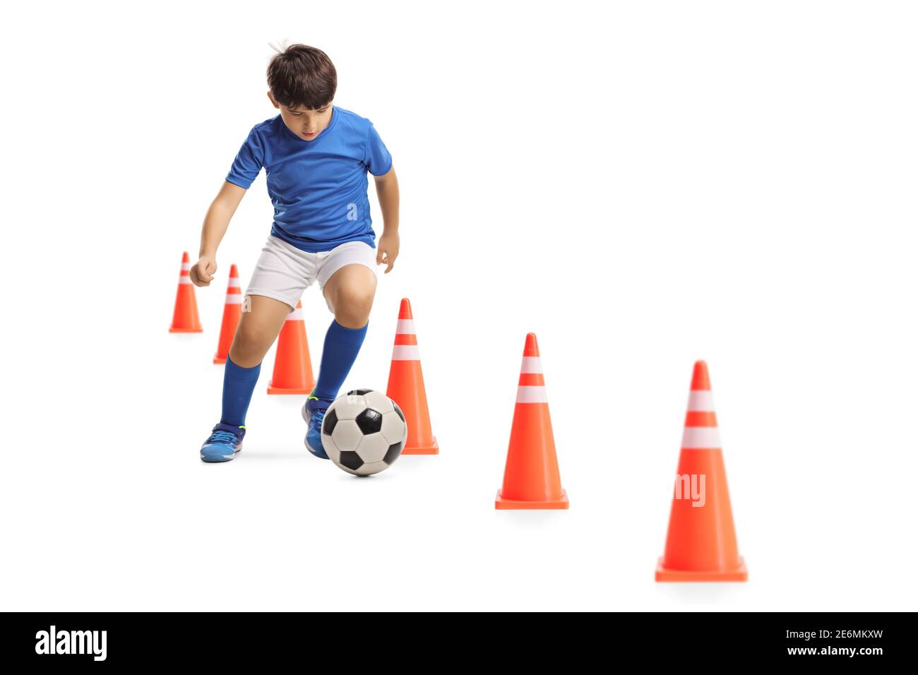 Boy allenando calcio con coni di ostacolo isolati su sfondo bianco Foto Stock