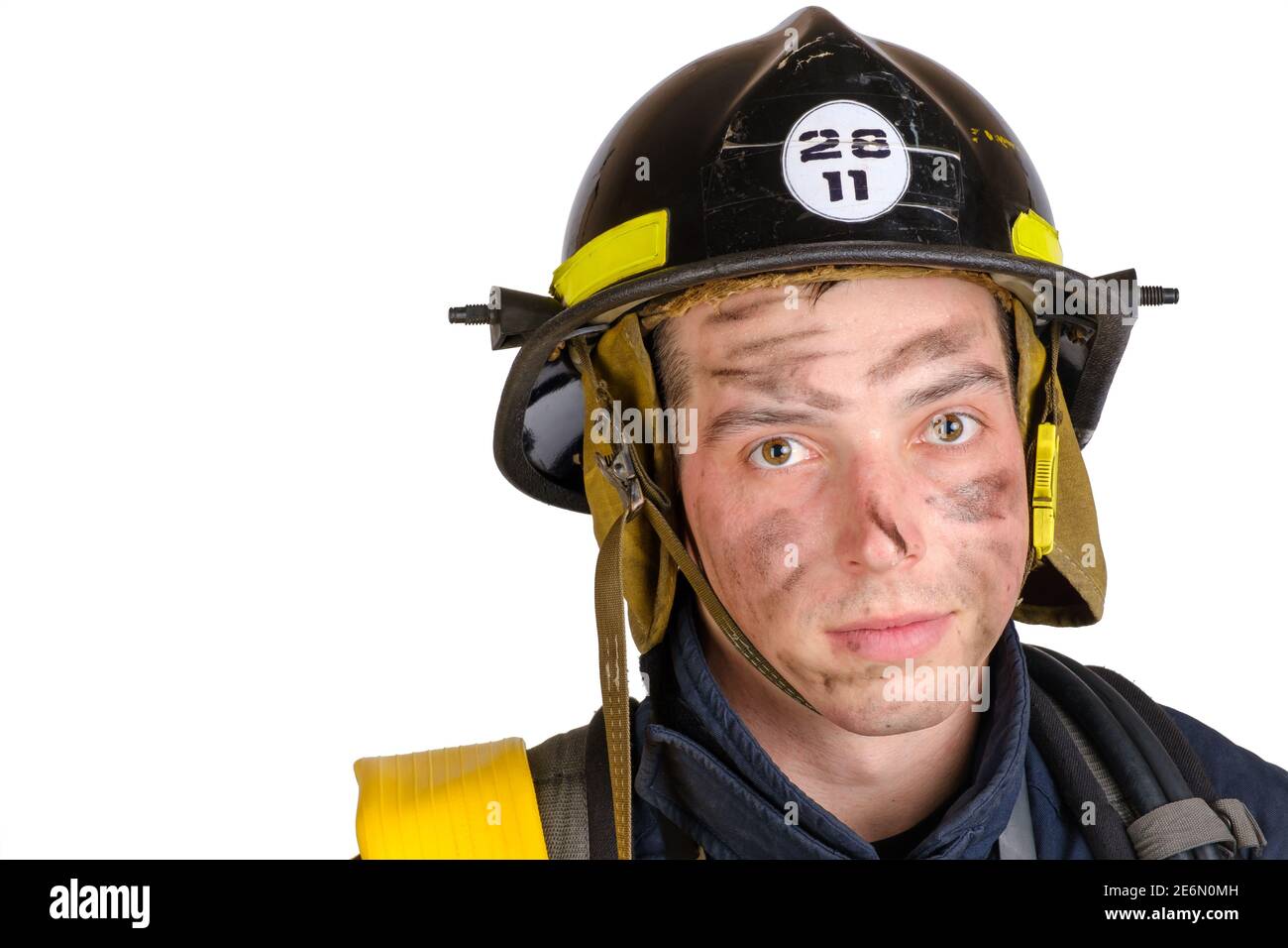 Primo piano di un giovane uomo coraggioso in uniforme e con cappello di vigili del fuoco Foto Stock