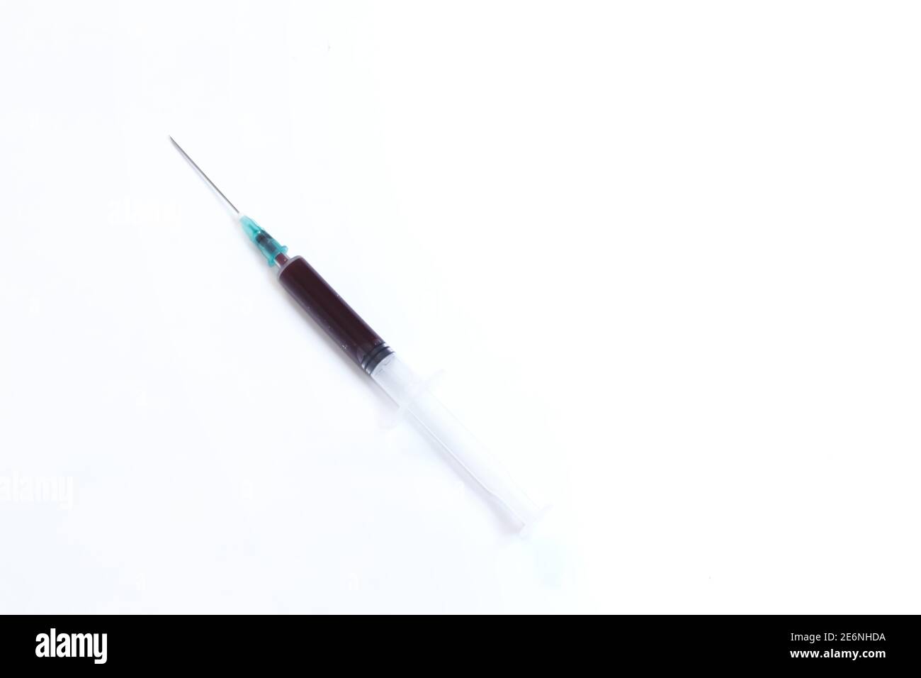 Siringa medica con sangue interno isolato su sfondo bianco con spazio per il testo. Campione di sangue prelevato a scopo di analisi. Spazio di copia. Foto Stock