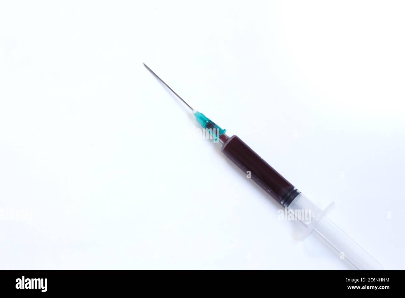 Siringa medica con sangue interno isolato su sfondo bianco con spazio per il testo. Campione di sangue prelevato a scopo di analisi. Spazio di copia. Foto Stock